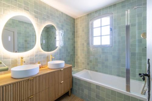 a bathroom with two sinks and a tub at Charmante maison sur Marseille in Marseille