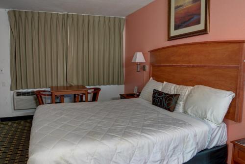 a hotel room with a large bed and a table at The Palms Motel in Portland
