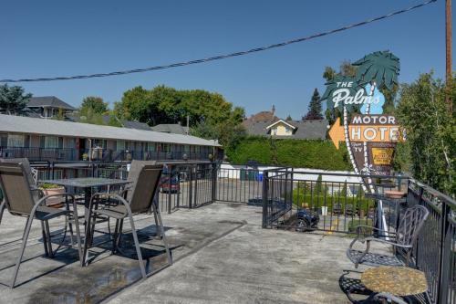a patio with a table and chairs in front of a hotel at The Palms Motel in Portland