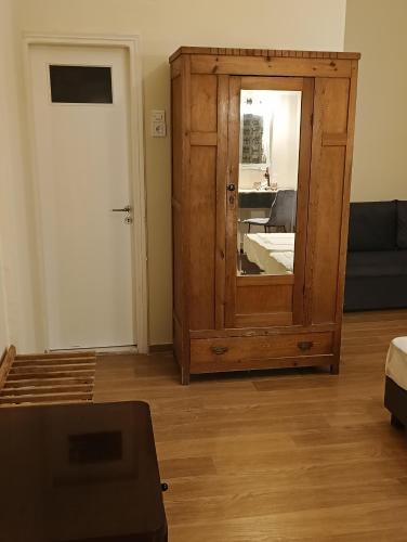 a room with a wooden cabinet with a mirror at Anesis Hotel in Loutra Edipsou