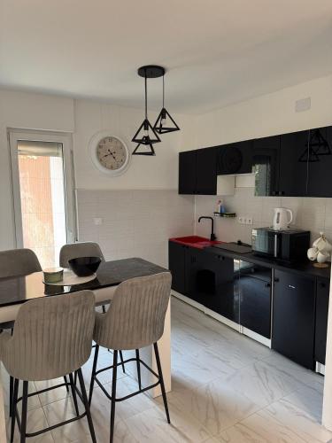 ドニー・ミラノヴァツにあるApartman Ćetkovićのキッチン(黒いキャビネット、テーブル、椅子付)