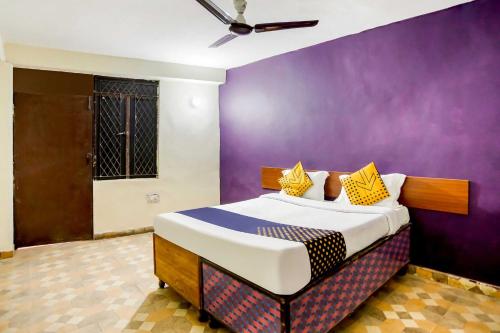une chambre avec un lit avec un mur violet dans l'établissement SPOT ON Hotel Harry's 1 Near Select Citywalk Mall, à New Delhi