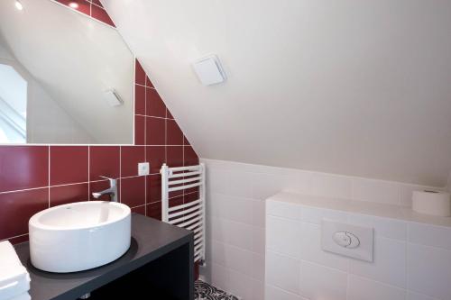 un bagno con lavandino e specchio di Les vignes blanches a Beaune