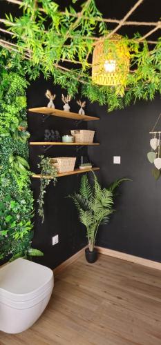 a room with a toilet and plants on a wall at Suite Mahé in Port-de-Bouc