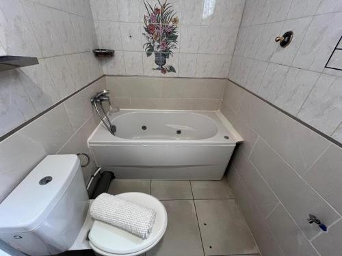 a bathroom with a toilet and a bath tub at Duplex La Petite Perle avec son jardin privé in Le Lamentin