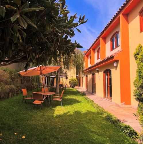 a patio with a table and chairs and an umbrella at Hotel Meliana in Arequipa
