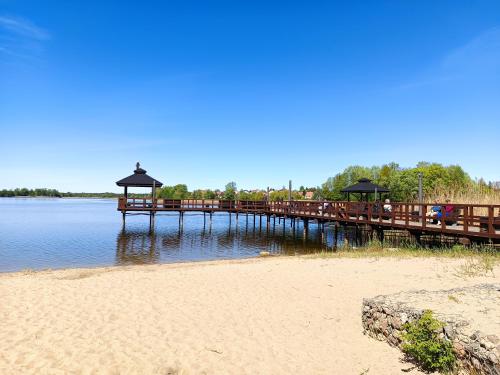 a wooden pier on the beach with a sandy beach at Anders Home 1 Szczytno in Szczytno