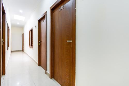 a corridor of a hospital with wooden doors at Hotel O Sabtera Homes in Kharar