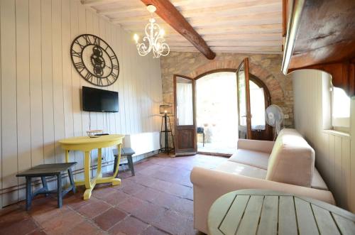 a living room with a couch and a clock on the wall at Celle di lecchi Porcilaia in San Sano