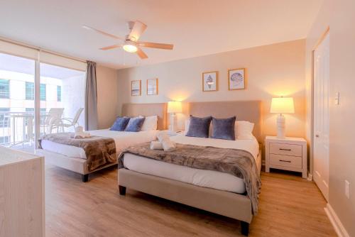 a bedroom with two beds and a ceiling fan at Brickell Condo w City View & Pool Access in Miami