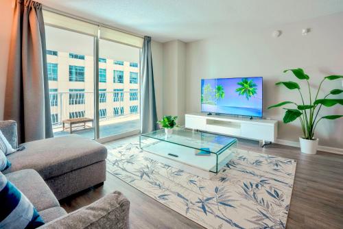 a living room with a couch and a tv at Brickell Condo w City View & Pool Access in Miami