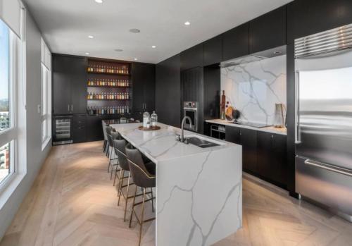 a kitchen with black cabinets and a bar with stools at Upscale Midtown Retreat , Free Parking & Close to Mercedes-Benz in Atlanta