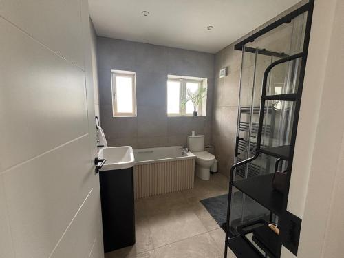 a bathroom with a tub and a sink and a toilet at Slieve Rua Drive in Blackrock