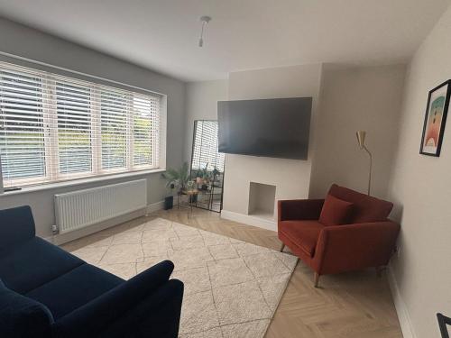 a living room with two chairs and a flat screen tv at Slieve Rua Drive in Blackrock