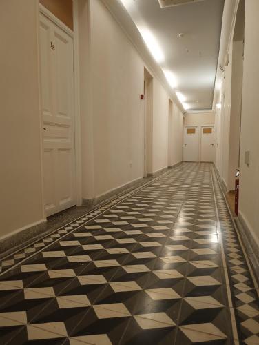 a hallway with a black and white tiled floor at Anesis Hotel in Loutra Edipsou