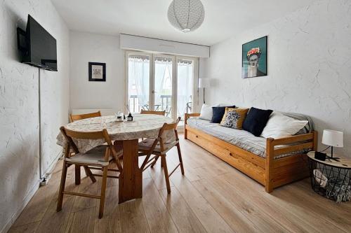 un salon avec une table et un canapé dans l'établissement Cozy and bright renovated apartment, à Villers-sur-Mer