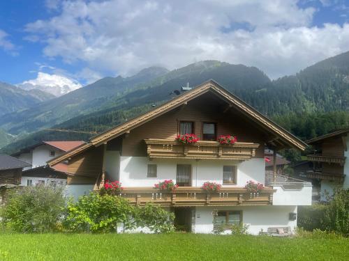 a house with flower boxes on the balcony of it at Appartements Alpenblick in Finkenberg