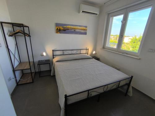 a bedroom with a bed and two windows at La casa del Turista Appartment in Gallipoli