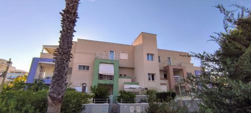 a large pink building with trees in front of it at La casa del Turista Appartment in Gallipoli