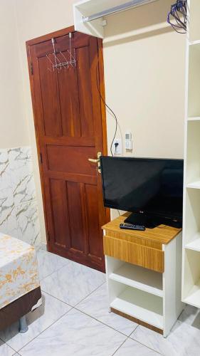a door in a room with a television and a door at Kitnet_Familiar 2/4 in Boa Vista
