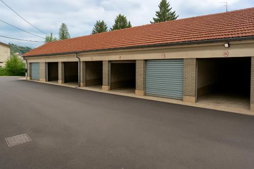 a building with two garage doors and a parking lot at Hotel De L'Europe in Toul