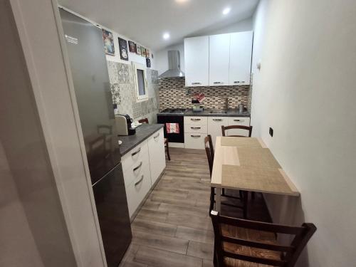 a kitchen with white cabinets and a table with chairs at Imperial Apartment in Rome
