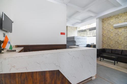 a large white counter in a room with a couch at Hotel O Sunshine Inn Near Pune Railway Station in Pune