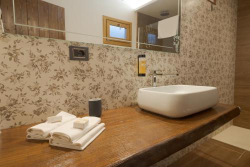 a bathroom with a sink and towels on a wooden counter at Agri-Hotel Da Marianna Resort & Spa in Santa Domenica Vittoria