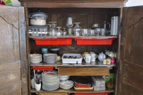 une armoire remplie de vaisselle et d'autres articles dans l'établissement Le Grand Bleu, à Wimereux
