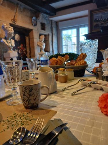 une table avec des ustensiles et une assiette de pain dessus dans l'établissement chambre d'hôtes avec petit déjeuner compris à Mégrit, à Mégrit