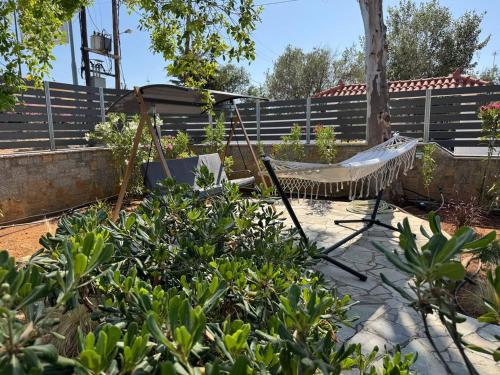 a hammock in a garden with a fence at Desire Apartments in Kato Gouves