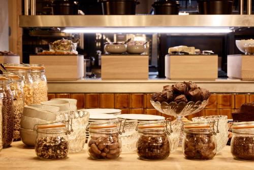 a table topped with jars of food and a counter with aasteryasteryasteryastery at Grand Mess Clermont-Ferrand in Clermont-Ferrand