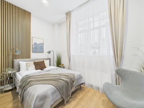 a bedroom with a bed and a chair and a window at P6-A Riga Old Town Apartments in Rīga