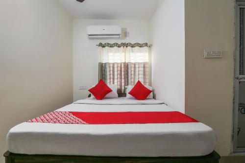 a bedroom with a large bed with red pillows at Hotel O Lokenath in Jamshedpur