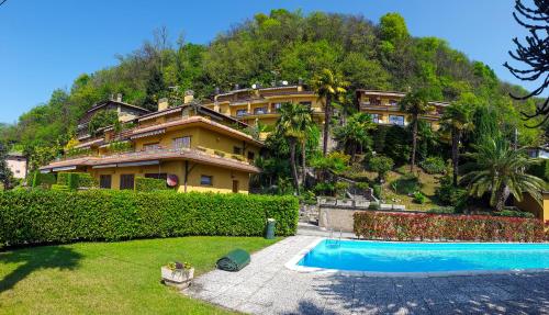 une grande maison avec une piscine devant dans l'établissement Vista Maccagno, à Maccagno Inferiore