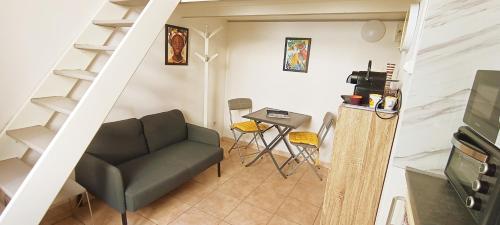 - un salon avec un escalier, un canapé et une table dans l'établissement joli studio proche tram et au calme, à Nice
