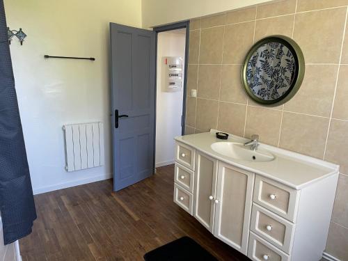 La salle de bains est pourvue d'un lavabo, d'un miroir et d'une porte. dans l'établissement Le Moulin, à Argol