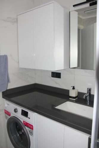 a kitchen with a washing machine and a sink at Villa Sarisli 3 in Ortaca