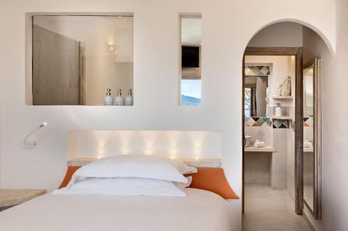 a bedroom with a white bed and a mirror at Hotel Capo d'Orso Thalasso & SPA in Palau