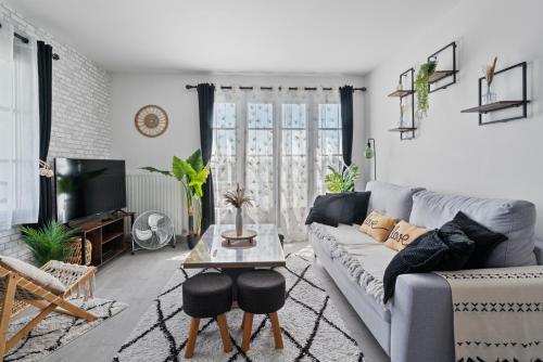 un salon avec un canapé et une table dans l'établissement Park' Avenue Cocon pour 6 personnes à Disneyland, à Serris