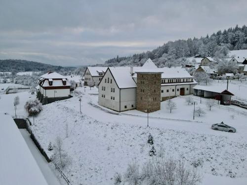 a town covered in snow with buildings and cars at Hotelový a jezdecký areál Dvůr Krutěnice in Krutěnice