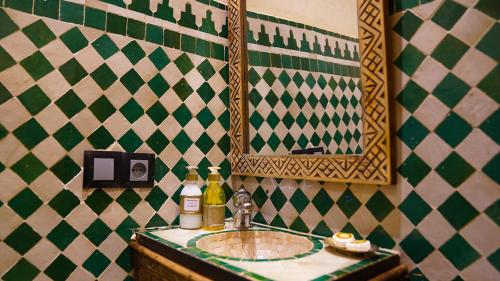 a bathroom with a sink and a mirror at Riad Touhfa Kasbah Marrakech in Marrakech