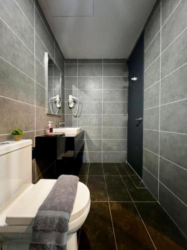 a bathroom with a toilet and a sink and a tub at Sunway Onsen Ipoh by EUcation Home in Tambun
