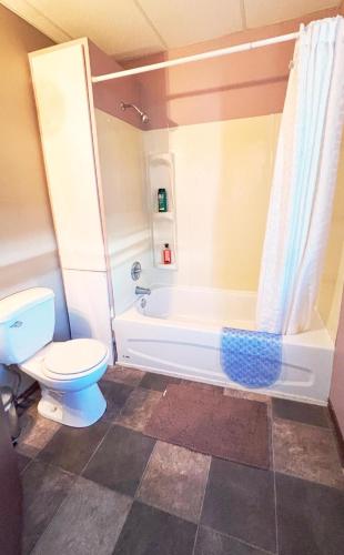 a bathroom with a white tub and a toilet at Wakaw Inn in Wakaw