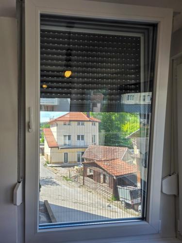 a window with a view of a house at Urban Nest in Jajce