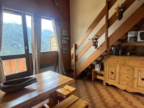 Cette chambre dispose d'une table en bois et d'une grande fenêtre. dans l'établissement Châtel : Duplex cosy pour 4 pers avec coin montagne - FR-1-198-268, à Châtel