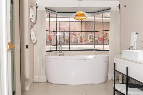 a bathroom with a large tub in front of a window at Illa Experience Hotel in Quito