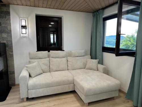 a living room with a couch and a window at Csipetnyi Chill Vendégház in Óbudavár