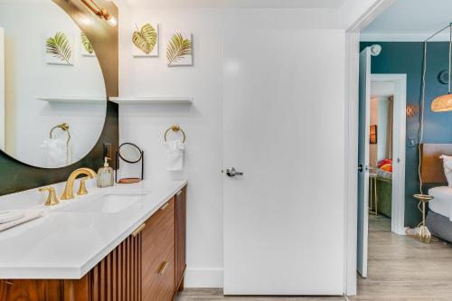a bathroom with a sink and a mirror at Modern 3BR 3BA Grove Condo Views Balconies Full Kitchen 3 Parking in Miami
