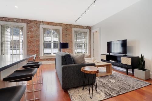 a living room with a couch and a television at Roami at Factors Row in New Orleans